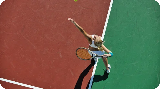 top view of female tennis player serving the ball on a green court, capturing precision, technique, and professional tennis training moment
